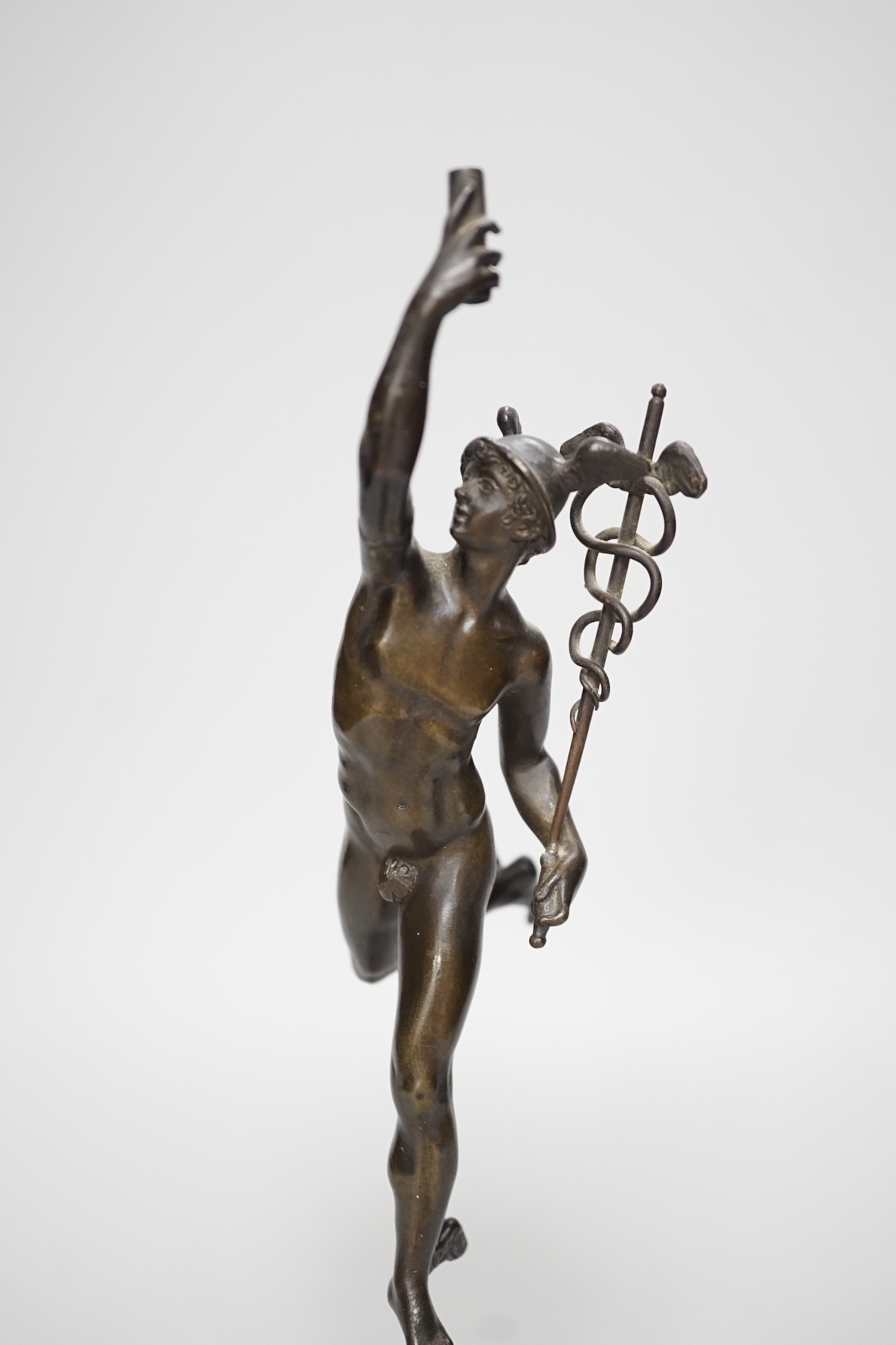 A bronze figure of Mercury on a graduated marble plinth. 33cm tall